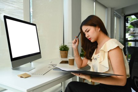 Téléchargez les photos : Femme entrepreneure asiatique frustrée regardant stressée tout en travaillant avec des rapports financiers au bureau. - en image libre de droit