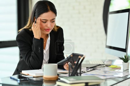 Téléchargez les photos : Femme d'affaires frustrée tenant sa main fatiguée et stressée alors qu'elle était assise au bureau. - en image libre de droit