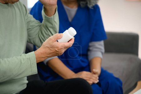 Foto de Trabajador sanitario explicando la dosis de medicamentos al paciente maduro en casa. Concepto sanitario. - Imagen libre de derechos