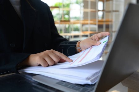 Foto de Empresaria profesional que trabaja con informes financieros y utiliza el ordenador portátil en el escritorio. - Imagen libre de derechos