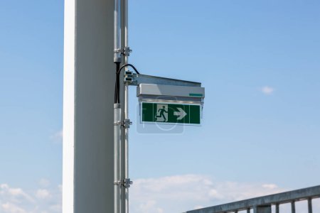 Photo for Emergency exit indicator on a metal pillar - Royalty Free Image