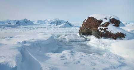Foto de Montaña de nieve Antártica paisaje de invierno. Vuela sobre el desierto virgen de la Antártida. Impresionante viaje a la helada tierra nevada del Ártico. Viajar, explorar maravillas heladas. Vuelo en avión no tripulado de ángulo bajo - Imagen libre de derechos