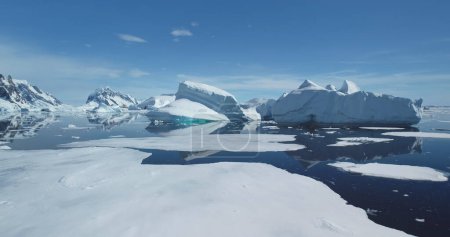 Eisberge vom schmelzenden Gletscher treiben an sonnigen Tagen im eisigen Ozean. Globale Erwärmung und Klimawandel. Filmische Ökologie-Szene. Schönheit wilder unberührter arktischer Natur. Tieffliegerdrohne abgeschossen