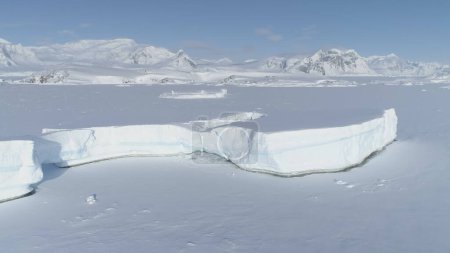 Foto de Vista aérea polar polar ártica congelada. Paisaje Antártico cubierto de nieve. Glaciar North Nature Coastline. Iceberg frío de invierno encerrado en hielo. Filmación en 4K UHD
. - Imagen libre de derechos