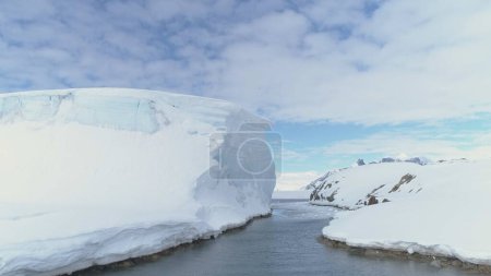 Foto de Ocean Pass Through Iceberg And Snow Antarctica Land (en inglés). Visión general del vuelo aéreo con drones. Glaciares cubiertos de hielo y nieve del continente antártico. Paisaje polar de invierno. Silvestre. Filmación 4k
. - Imagen libre de derechos