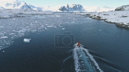 Téléchargez les photos : Zodiac Boat in Antarctica Ocean Aerial Shot. Drone Flight Overview of South Pole Antarctic Glacier. Flotteur de bateau en caoutchouc dans le paysage d'eau d'hiver gelé parmi la côte de glace. Tournage en 4K UHD - en image libre de droit