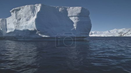 Antarctica Aerial Flight Over Polar Ocean To Iceberg. Amazing Winter Scenery. Huge Sunlit Ice Mountain Among Cold Antarctic Ocean. Massive Iceberg With Arch. Winter Landscape. Wilderness. 4k Footage.