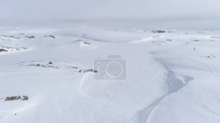 Snowmobile Drive on Snow Arctic Majestic Landscape. Drone Flight Shot of Ski-doo Rider in Nature Winter Antarctica Expedition. Extreme Adrenaline Lifestyle in Iceland Aerial Footage 4K UHD