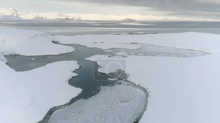 Antarctic Snow Covered Shore Aerial Drone Zoom in View to Old British Base Near Vernadsky Polar Station. Arctic Frozen Ocean Coast Shore Lean Landscape Panoramic Flight Overview. North Nature Seascape