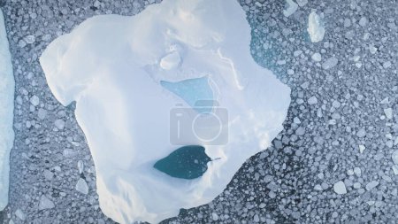 Eisberg aus nächster Nähe. Drohnenflug aus der Luft. antarktische Landschaft. Blick von oben auf den Eisberg. Eisstücke im polaren Meerwasser. antarktischer Kontinent. Vergrößerungsschuss. 4k Filmmaterial.