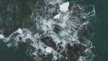 Foto de Ocean Wave Snow Rock Vista aérea desde arriba hacia abajo. Hermoso acantilado de la costa en espuma del abismo del agua. Power Sea Aqua Surf Invierno Antártida Paisaje marino Naturaleza Drone Flight Footage Shot 4K UHD - Imagen libre de derechos