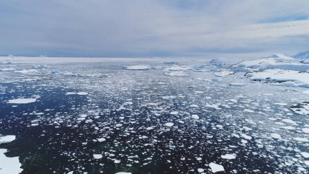 Téléchargez les photos : Changement climatique : fonte des glaces. Vol aérien au-dessus de l'Antarctique Eau glacée de l'océan. Vue d'ensemble du drone de l'océan polaire. Morceaux de glace, neige flottant dans l'eau froide. Environnement sauvage intact - en image libre de droit