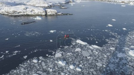 Zodiac Boat Sail Brash Ice Water Tracking Pan Shot. Drone Flight Above Transport Rubber Boat Float in Extreme Winter Open Water. South Pole Ocean Landscape Footage Shot in 4K UHD