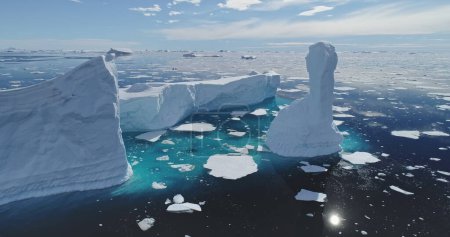 Global issue of climate change and melting icebergs on South Pole aerial. Uninhabited Antarctica environment and nature scape of seas and land in snow and ice at sun winter day. Warming clime