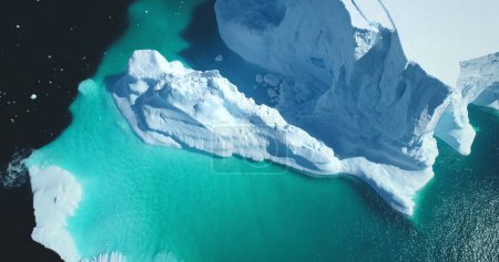 Schmelzender schneebedeckter Gletscher in blauem Wasser Luftaufnahme. Die Schönheit der Natur ragt aus einem schwimmenden Eisberg. Polare Winterlandschaft. Ökologie, schmelzendes Eis, Klimawandel, globale Erwärmung. Drohnenschuss