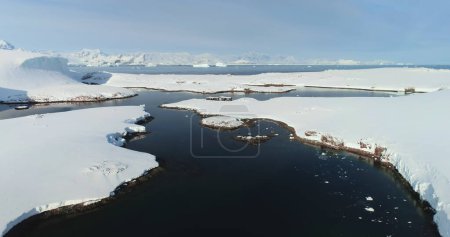 Foto de Volar por encima de panorama congelado de la Antártida y el viejo edificio de madera ciencia polar. Antártida majestuosa vista del dron paisaje. Impresionante armonía de la naturaleza intacta. Paisaje oceánico polar congelado - Imagen libre de derechos