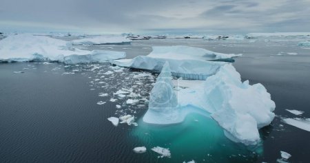 Treibende Eisberge in der arktischen Winterlandschaft. Antarktis schmilzt Gletscher mit blauem Wasser Umweltökologische Frage der globalen Erwärmung. Der polare Klimawandel am Wintertag. Drohnenpanorama aus der Luft