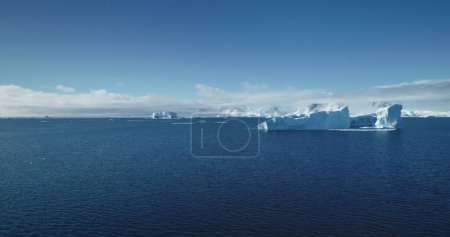 Vol de drone océanique bleu Antarctique froid. Les icebergs des glaciers fondus flottant par temps ensoleillé. Scène d'été polaire. Ecology, melting ice, climate change, global warming concept. Contexte naturel