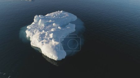 Iceberg Float in Clear Water Ocean Drone Above View. Huge Ice Melt in Ocean, Global Climate Change Concept Pan Right Flight. Winter Polar Glacier Landscape.