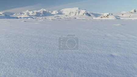 Panorama of scientific base in Infinitely, Infinitely polar snowy Antarctica desert. South Pole frost surface. Snow covered mountains on horizon. Aerial view flight. Ice Landscape. Winter frozen