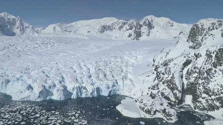 Foto de Vuelo aéreo sobre la Antártida Montañas cubiertas de nieve, Océano Polar. Increíble Drone Descripción general del paisaje de invierno blanco. Viaje exótico a la naturaleza antártica. Belleza de la naturaleza virgen. - Imagen libre de derechos