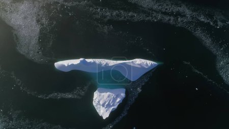 Antarktis-Eisberg-Drohnenflug. Schnell von oben nach unten. Überblicken Sie den einsamen schneeweißen Eisberg inmitten polaren winterlichen Meerwassers. Schönheit wilder, unberührter Natur. .