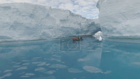 Segelboot zwischen Eisbergen im antarktischen Polarmeer. Epische Winterlandschaft. Touristisches Zodiac Boot unternimmt eine extreme Kreuzfahrt. Kristallklares blaues Ozeanwasser und Eisberge.