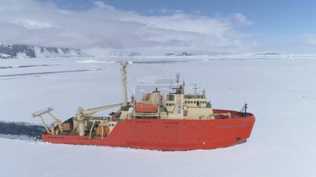 Téléchargez les photos : ANTARCTIQUE DE L'OUEST - 23 NOV 2017 : brise-glace antarctique Vue aérienne du glacier. Laurence M. Gould Navire de recherche Voyage à travers la surface gelée de l'océan Austral à la côte Top Flight Copter - en image libre de droit