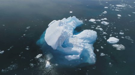 Close-up Iceberg Floating In Antarctica Ocean. Vuelo aéreo sobre el Polo Sur. Drone Overview of Massive Glacier In Clear Ocean (en inglés). Reflejo solar en agua pura. Naturaleza polar salvaje.