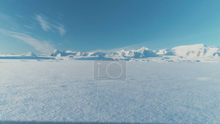 Foto de Infinitamente, infinitamente polar desierto nevado en la Antártida. Superficie helada del Polo Sur. Base científica. Montañas cubiertas de nieve en el horizonte. Vuelo de vista aérea. Paisaje de hielo. Mosca de dron congelada invierno - Imagen libre de derechos
