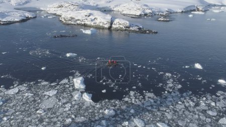 Zodiac Boat Sail Brash Ice Water Tracking Pan. Drone Flight Above Transport Rubber Boat Float in Extreme Winter Open Water. South Pole Ocean Landscape