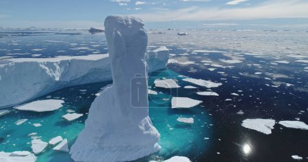 Sun reflection at arctic ocean with melting iceberg aerial. Environment ecological issue of global warming and rising seas problem. Polar climate change at sunny winter day. Cinematic ecology scene