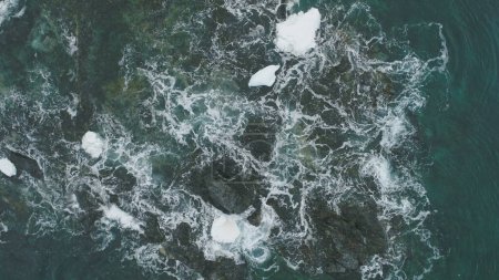 Foto de Ocean Wave Snow Rock Vista aérea desde arriba hacia abajo. Hermoso acantilado de la costa en espuma del abismo del agua. Power Sea Aqua Surf Invierno Antártida Paisaje marino Naturaleza Drone Flight - Imagen libre de derechos