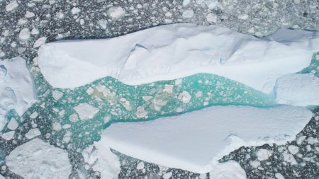 Turquoise Iceberg Brash Ice Aerial Top Down View. Huge Snow Ice Float in Ocean Arctic Coast, Global Warming Concept. Pole Nature Floating Glacier Seascape Drone