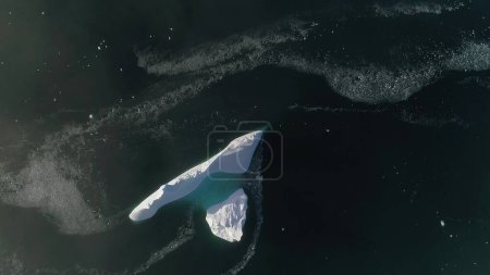 Antarktis-Eisberg-Drohnenflug. Schnell von oben nach unten. Überblicken Sie den einsamen schneeweißen Eisberg inmitten polaren winterlichen Meerwassers. Schönheit wilder, unberührter Natur. .