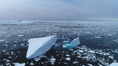 Antarctica melting blue water iceberg aerial view. Antarctic ocean environment. Ice nature landscape of global warming and climate change concept. Top Drone