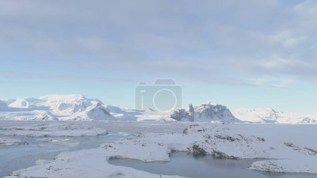 Foto de Drone Flight Over Antarctic Science Station - Academician Vernadsky (en inglés). Vista de la costa de nieve, océano, superficie del agua. South Pole Settlement Base Majestic Landscape. Vuelo aéreo de velocidad lenta - Imagen libre de derechos