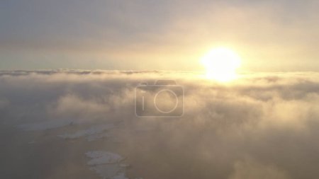 Coucher de soleil dans le brouillard ciel nuageux blanc. Vue aérienne du vol des drones. Vue panoramique épique le soleil orange jaune vif au-dessus du brouillard de surface en mouvement rapide couvrant l'Antarctique. Paysage écrasé. Incroyable. .
