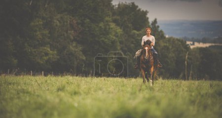 Téléchargez les photos : Jolie, jeune, rousse femme avec son beau cheval, pendant ses loisirs préférés - en image libre de droit