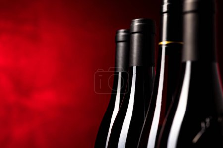 Téléchargez les photos : Bouteilles de vins rouges de qualité photographiées avec du DOF peu profond ; image couleur tonique - en image libre de droit