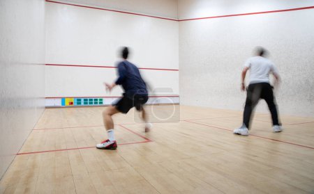 Téléchargez les photos : Joueurs de squash en action sur un court de squash (image floue de mouvement ; image tonique de couleur) - en image libre de droit