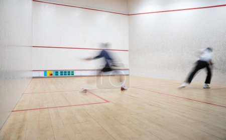 Téléchargez les photos : Joueurs de squash en action sur un court de squash (image floue de mouvement ; image tonique de couleur) - en image libre de droit
