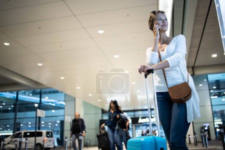 Foto de Mujer joven con su equipaje en un aeropuerto internacional, antes de pasar por el check-in y el control de seguridad antes de su vuelo - Imagen libre de derechos