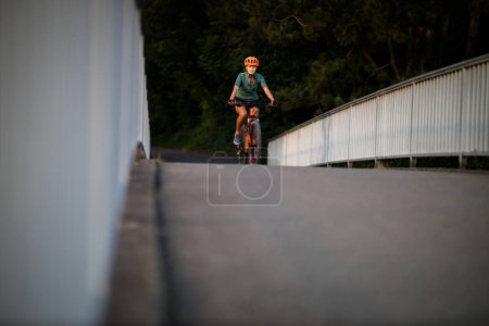 Téléchargez les photos : Jolie, jeune femme avec son vélo de montagne va faire un tour au-delà des limites de la ville, obtenir la dose cardio quotidienne - en image libre de droit