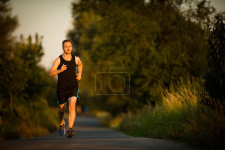 Foto de Tiro de un joven atleta entrenando en una pista de carreras. Sprinter corriendo en pistas de atletismo visto desde arriba - Imagen libre de derechos