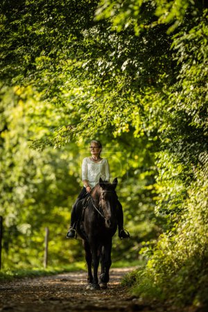 Foto de Mujer montando un caballo. Deportes ecuestres, concepto de equitación de ocio - Imagen libre de derechos
