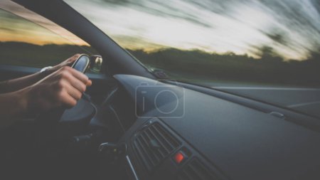 Téléchargez les photos : Mains d'un conducteur sur une roue d'une voiture (image floue mouvement) - en image libre de droit