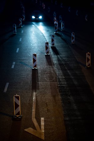 Téléchargez les photos : Voitures sur une route avec fermeture de la route. Il travaille sur la route. Circulation nocturne. - en image libre de droit
