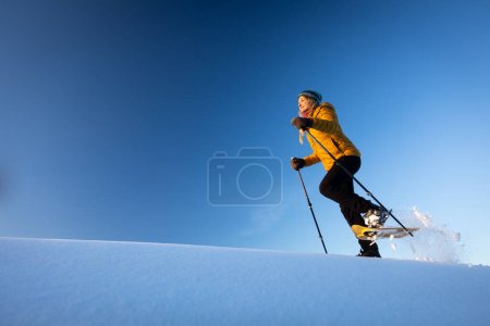 Photo for Snowshoeing in winter in deep snow. Walking in the snow. Hiking in the mountains in winter. - Royalty Free Image