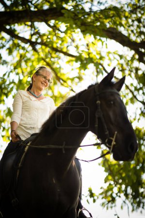 Foto de Mujer montando un caballo. Deportes ecuestres, concepto de equitación de ocio - Imagen libre de derechos